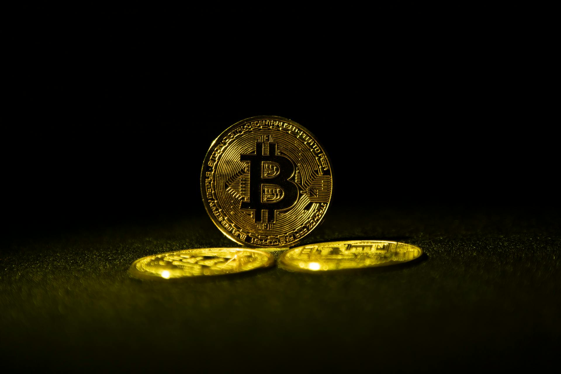 Golden Bitcoin coins symbolizing cryptocurrency wealth on a dark background.