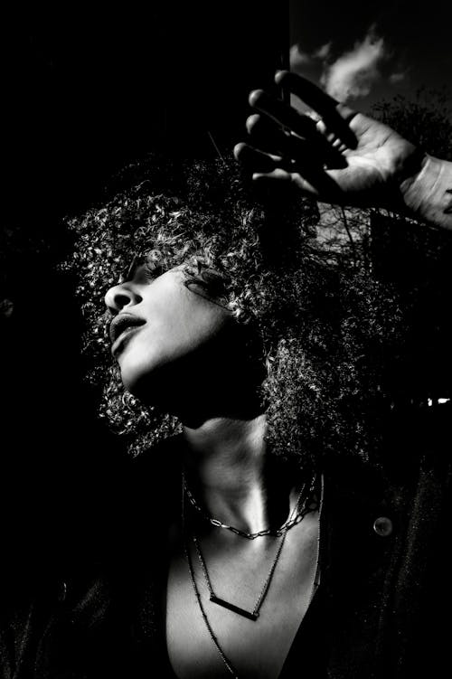 Beautiful Woman with Curly Hair Posing in Dark