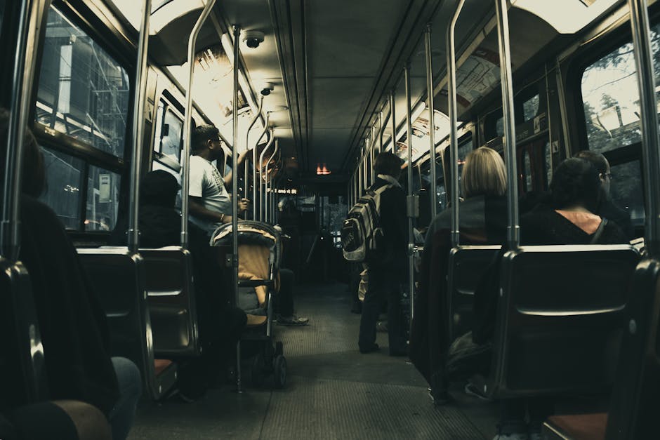 Man in White T Shirt Standing on the Bus