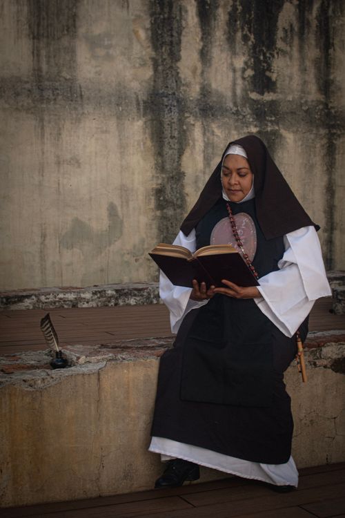 Free A nun reading a religious book outdoors in Ciudad de México, reflecting devotion and serenity. Stock Photo