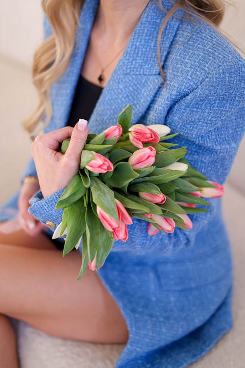 A woman in a blue blazer holding tulips