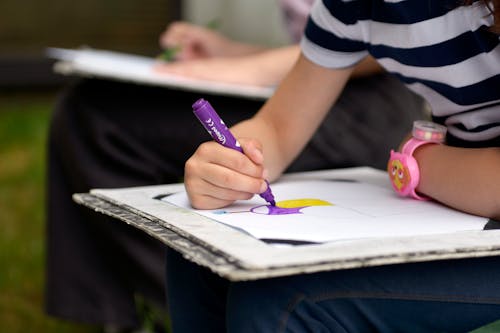 Hand of a Girl Drawing a Picture with a Felt Tip Pen