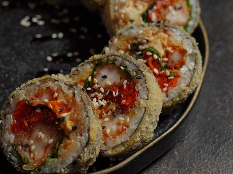 Close-up of delicious tempura sushi rolls topped with sesame seeds, perfect for food lovers.
