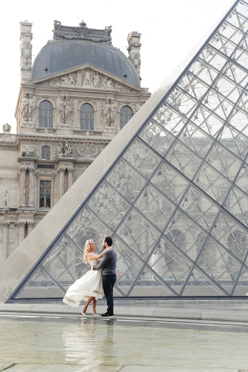 Newlyweds Embracing in Front of the Louvre Pyramid