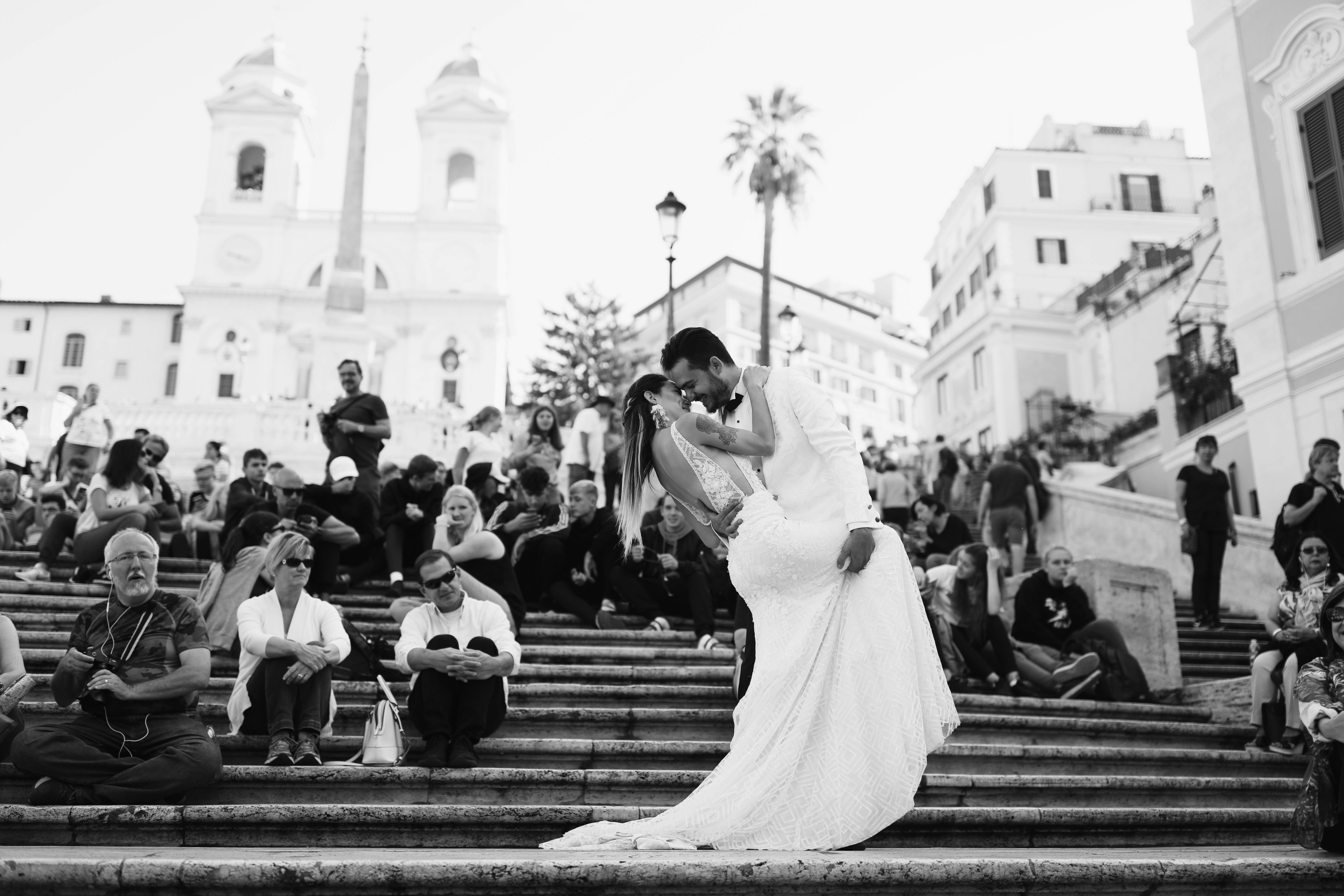 Elegant wedding couple kissing on iconic Spanish Steps in Rome. A stunning blend of romance and historic architecture.