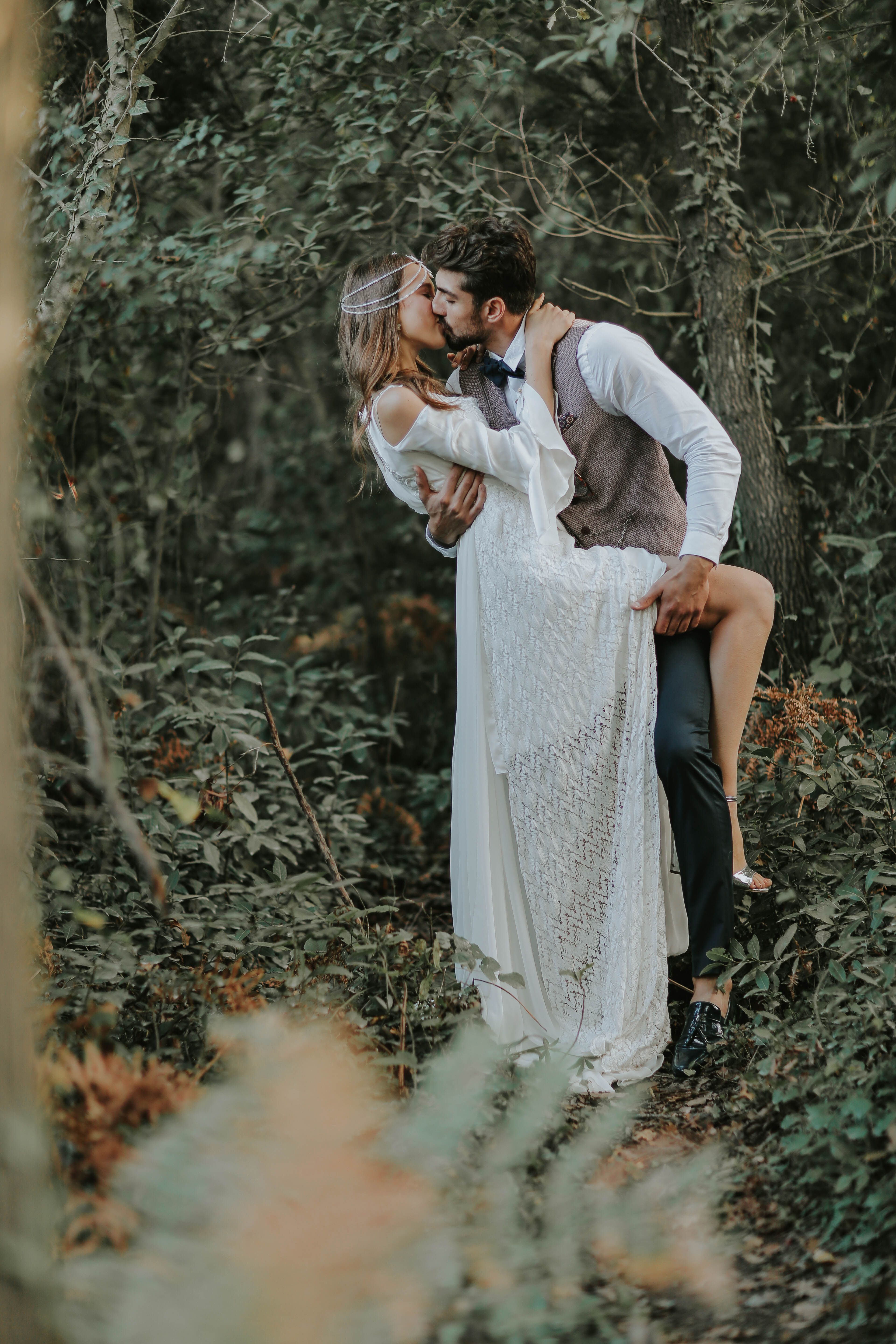 Newlyweds Kissing in a Forest · Free Stock Photo