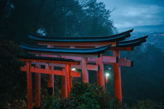 Dramatic blue hour view of Torii gates at Fushimi Inari Taisha in Kyoto, Japan.