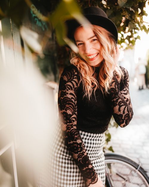 Free Blonde woman in a chic vintage outfit posing happily outdoors on a sunny day. Stock Photo