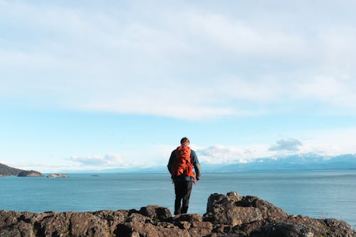 A man standing on a rock looking out to the ocean