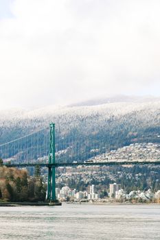 Lions Gate Bridge amidst mountains and urban skyline in Vancouver, Canada.