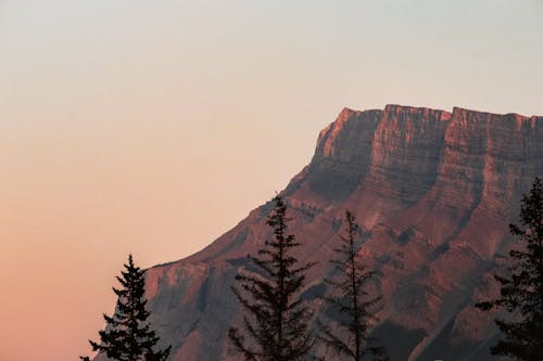 A mountain is silhouetted against the sky at sunset