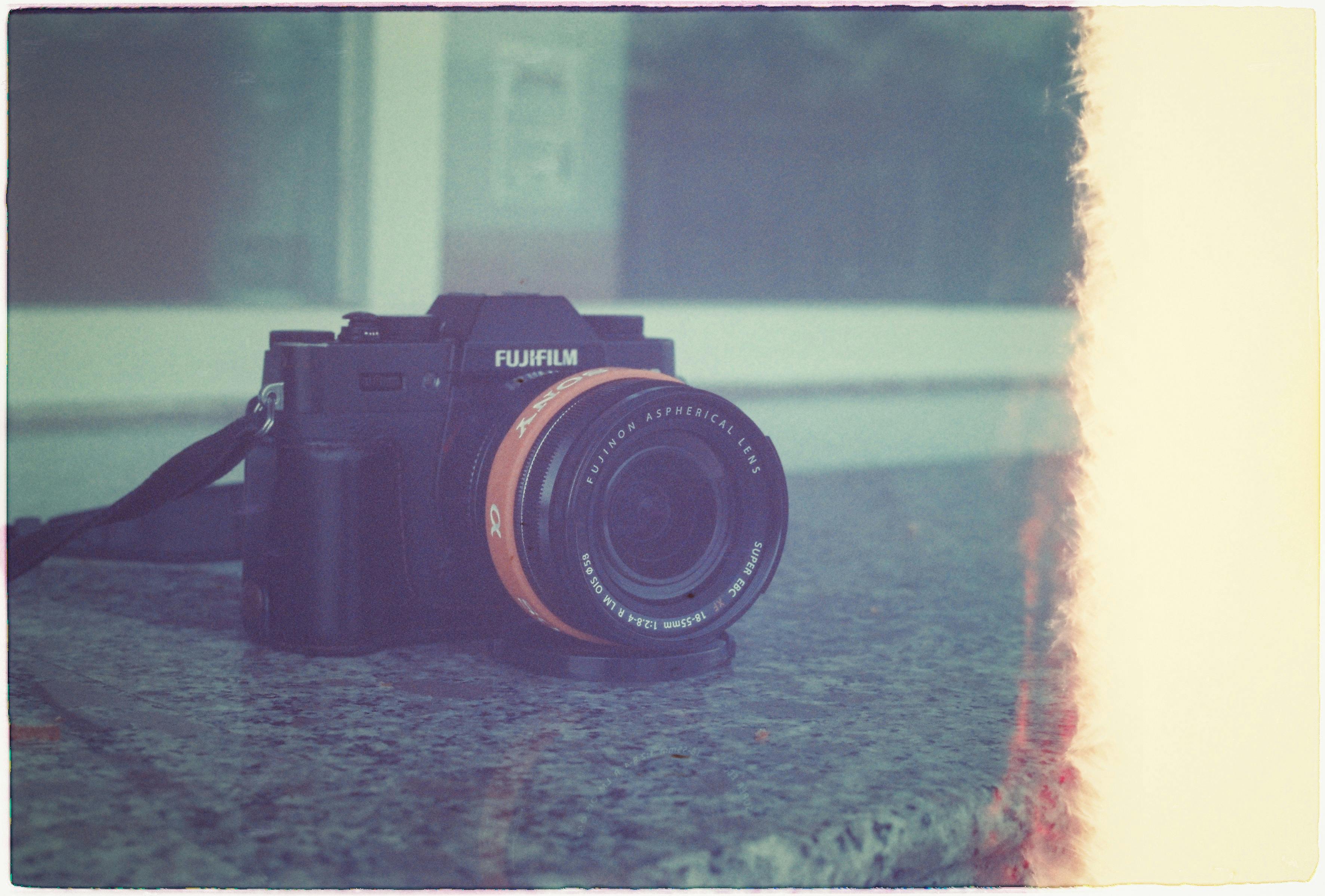 Retro-style photo of a Fujifilm camera on a granite surface, evoking nostalgia.