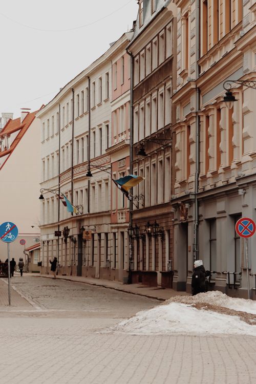 Free Discover a charming cobblestone street in Riga, Latvia, lined with historical townhouses and flags. Stock Photo