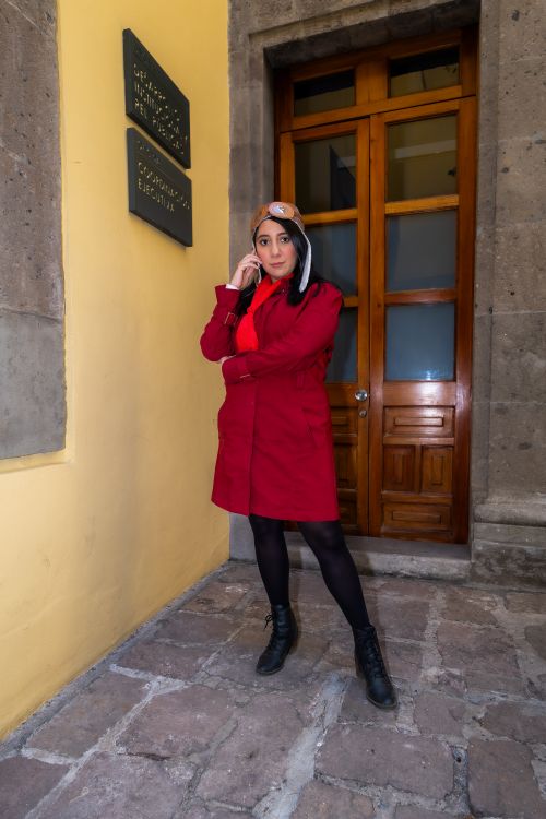Free Stylish woman in a red coat poses confidently in a narrow alleyway in Ciudad de México. Stock Photo