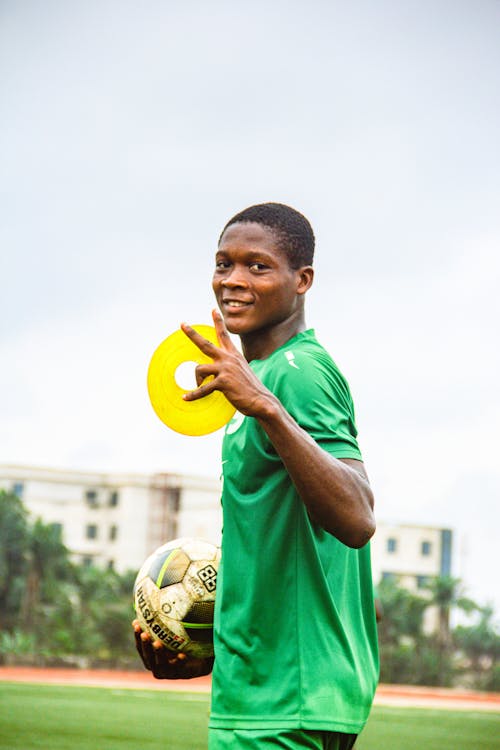 A young man in green holding a yellow disc