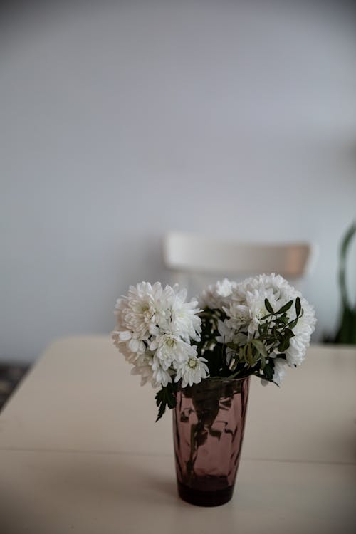 A vase with white flowers on a table