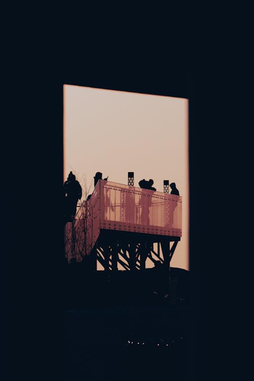Silhouettes of People Standing on Platform seen from Window