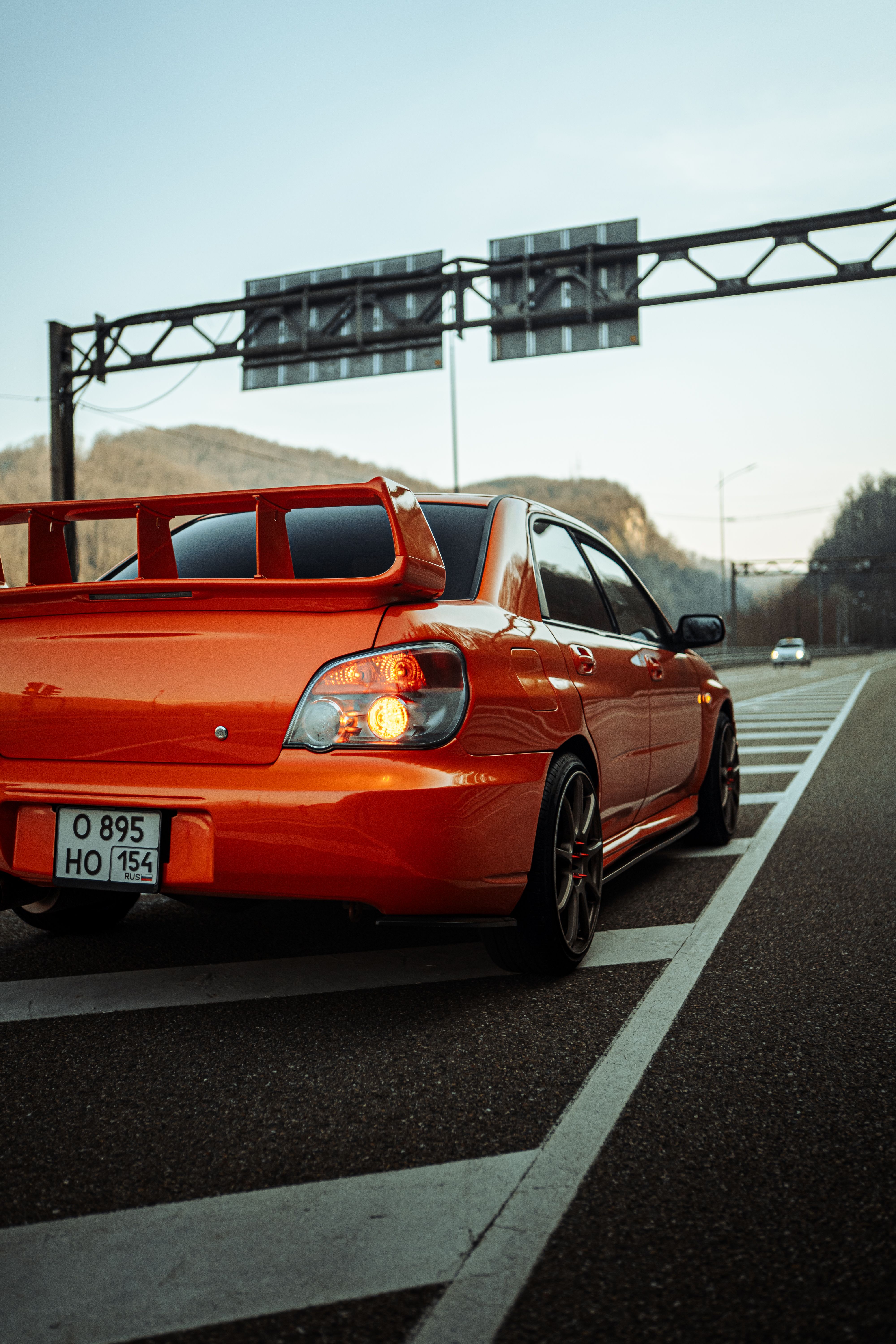 A red Subaru sports car parked on an urban road during the day, showcasing its sleek design.