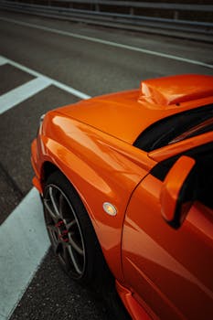 Stylish close-up of a red sports car parked on a city street, showcasing sleek design.