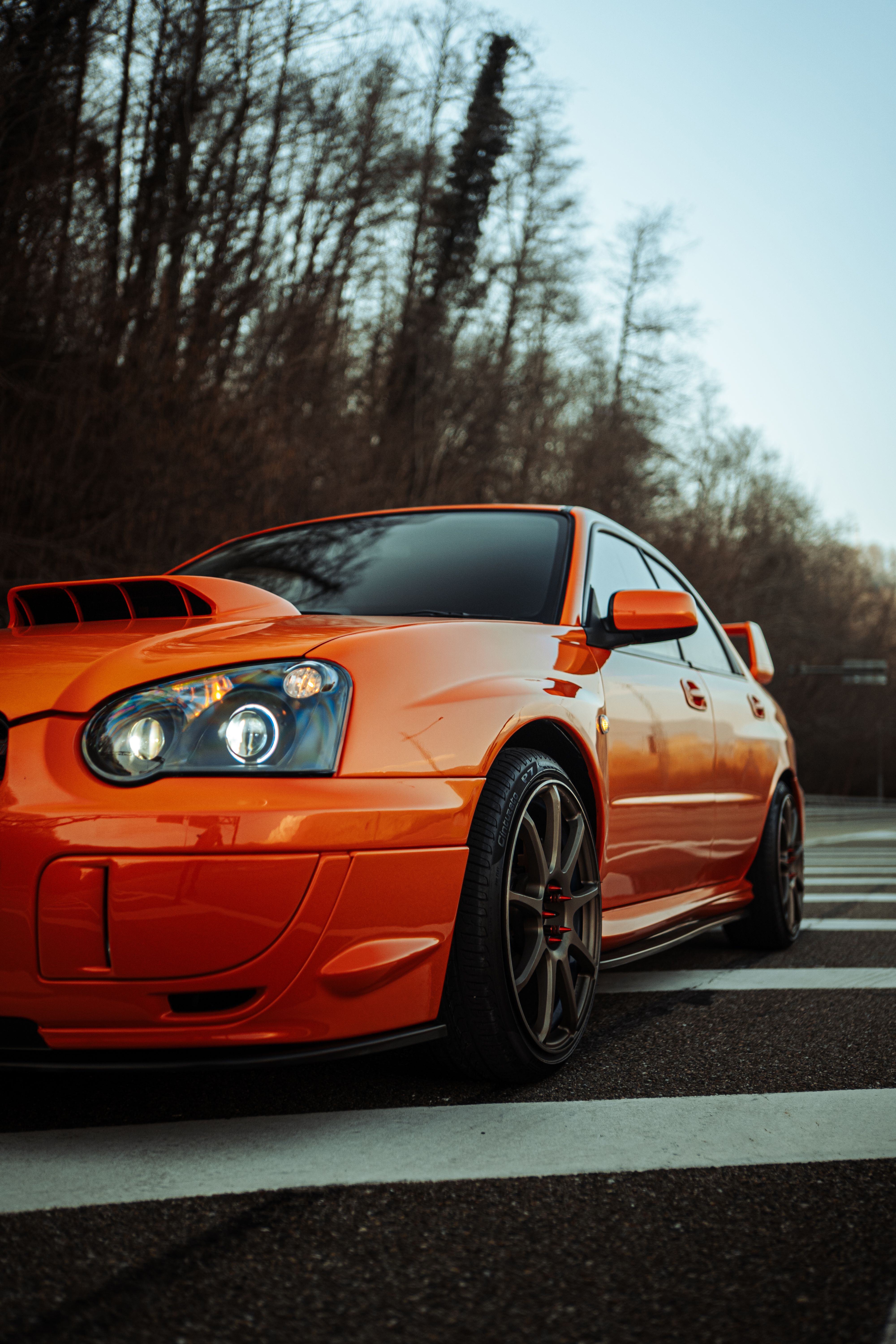 Vibrant red Subaru Impreza parked stylishly on an urban street, showcasing sleek automotive design.