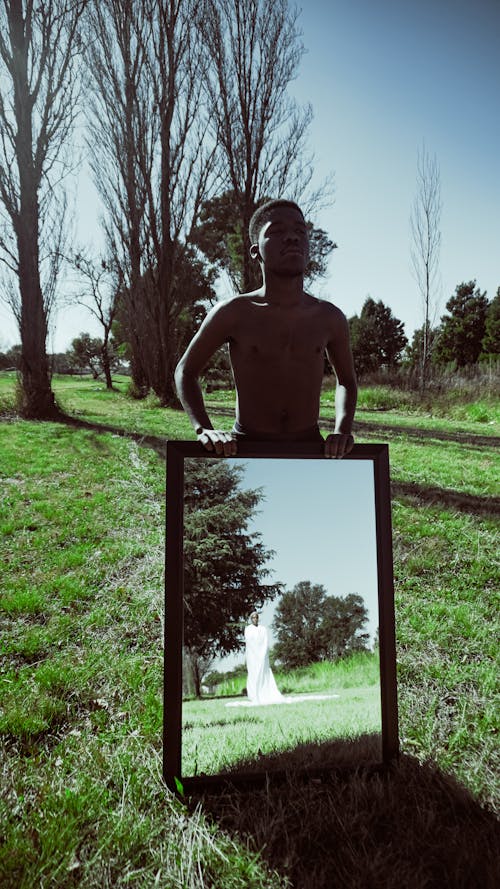 Man Holding a Mirror in a Park