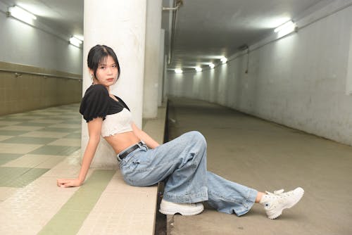 A woman sitting on the floor in a tunnel