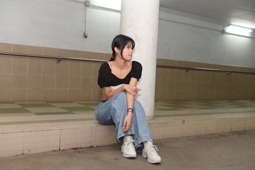 A woman sitting on the floor in a bathroom