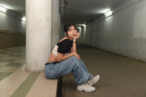 Woman Sitting on a Pavement in a Subway