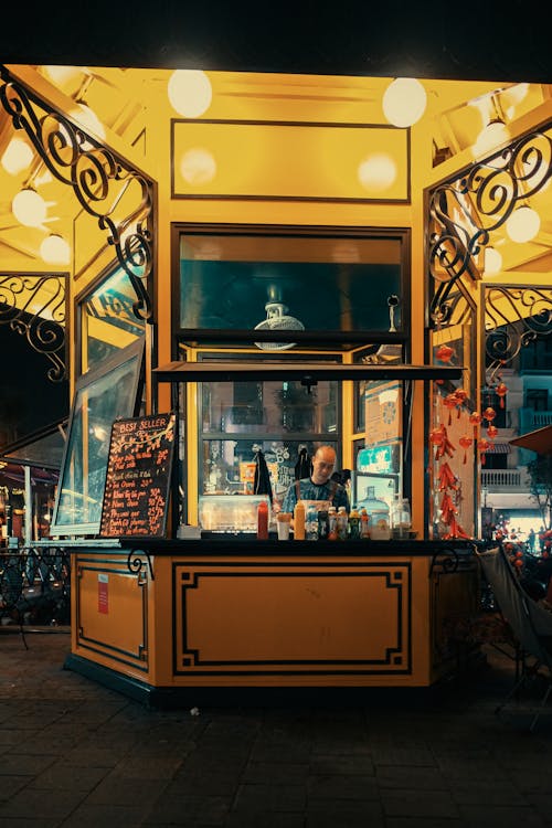 A yellow food stand with lights on it