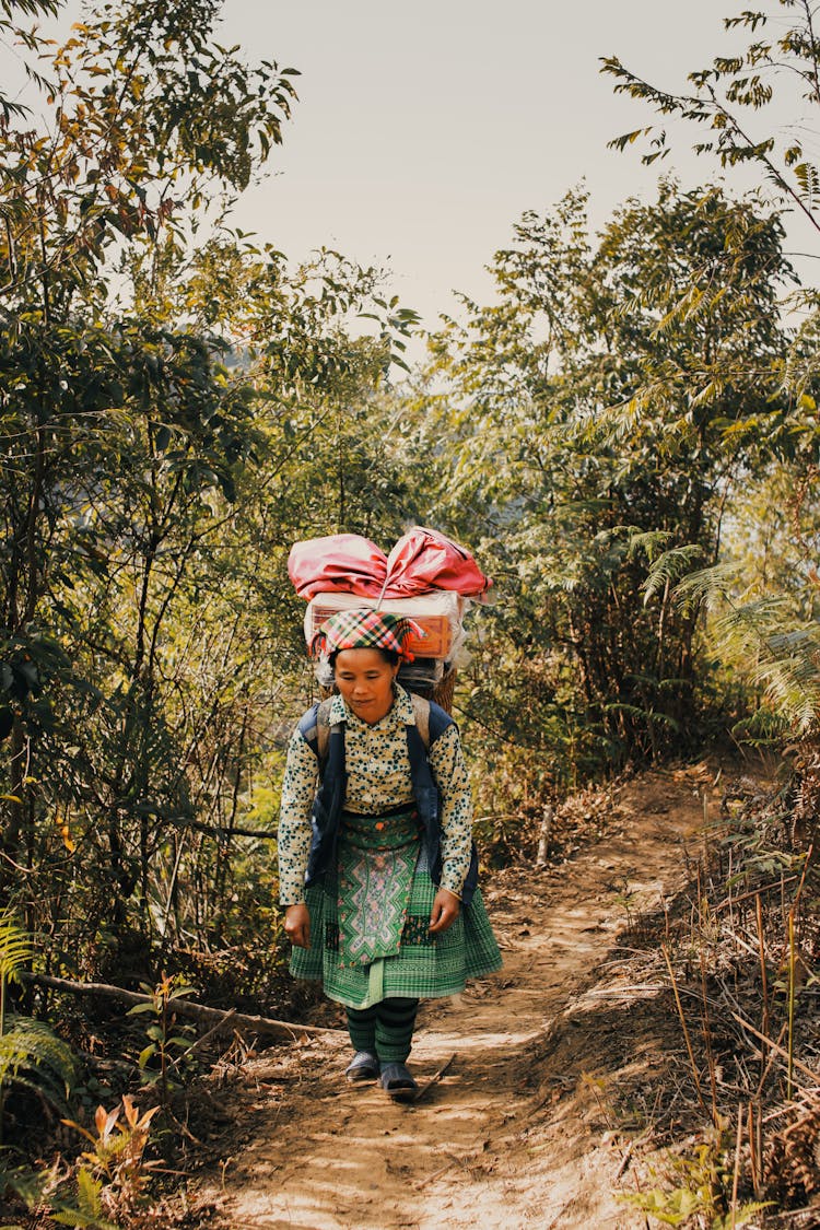 Elderly Woman In Traditional Clothing Walking With Backpack