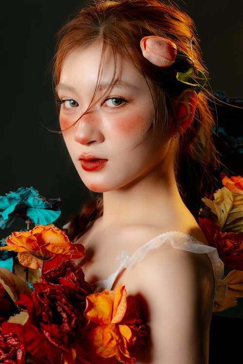 A woman with red hair and flowers on her face