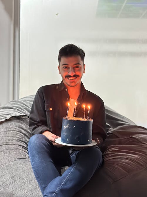 Free A man sitting on a bean bag with a cake Stock Photo