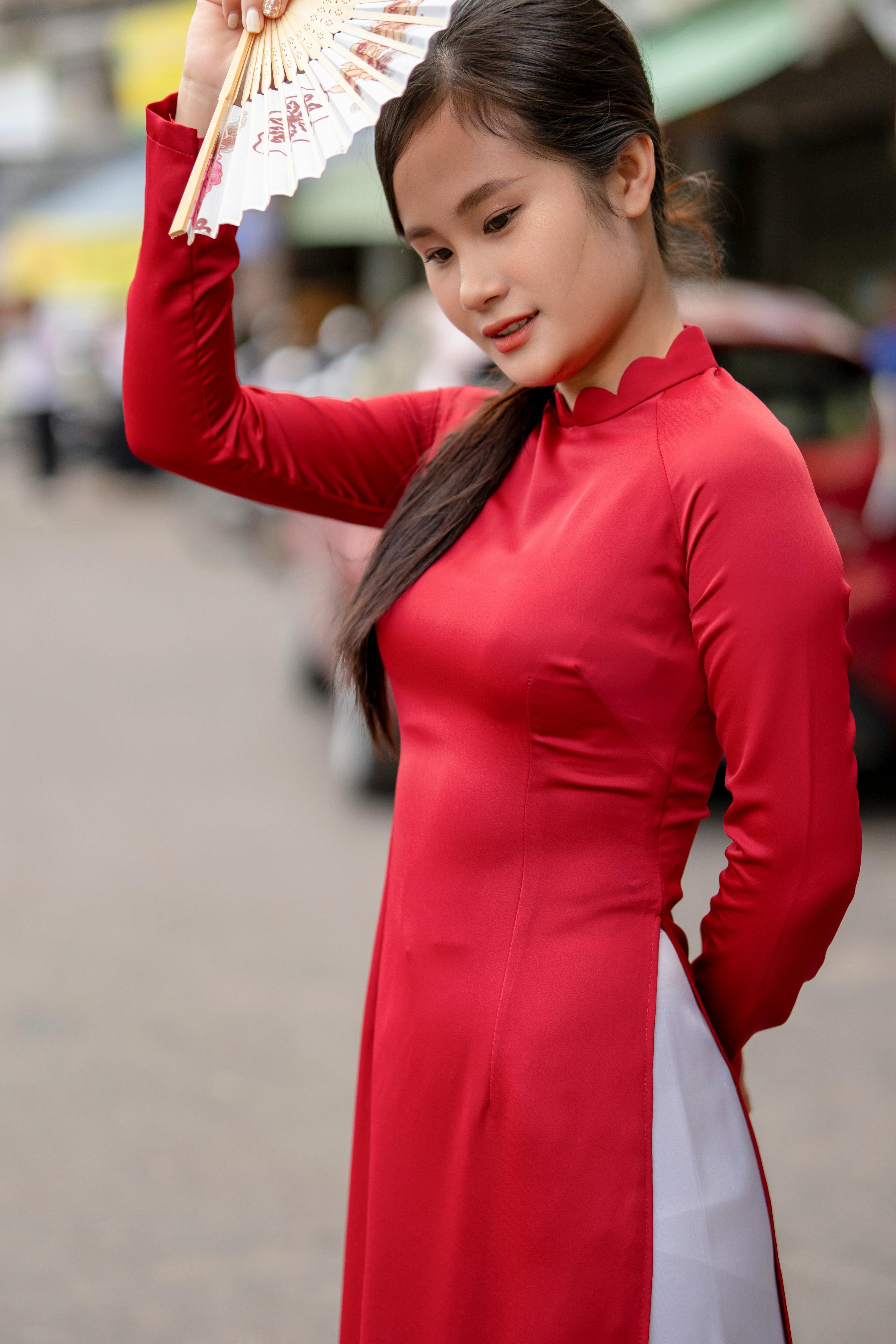 Portrait of a woman in traditional Vietnamese clothing holding a fan, exuding elegance and grace.