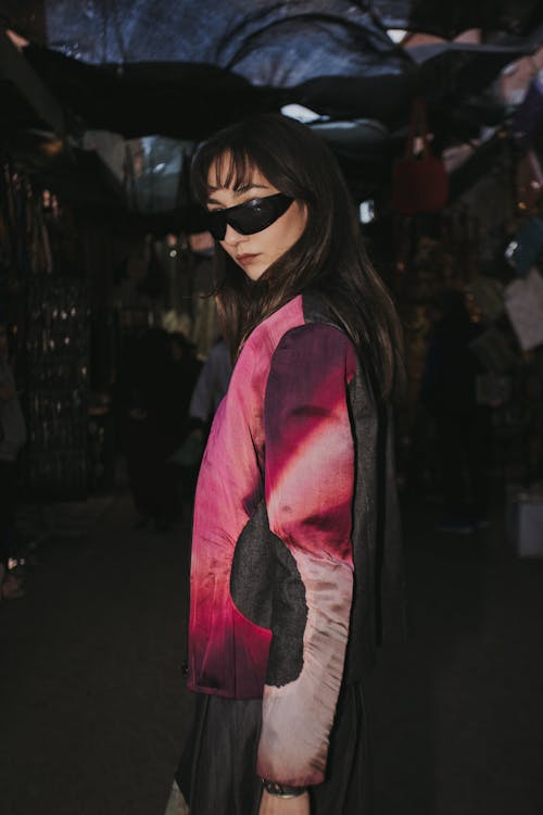 A woman in a pink jacket and sunglasses