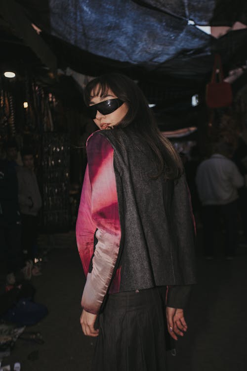 A woman in a black and grey jacket and sunglasses