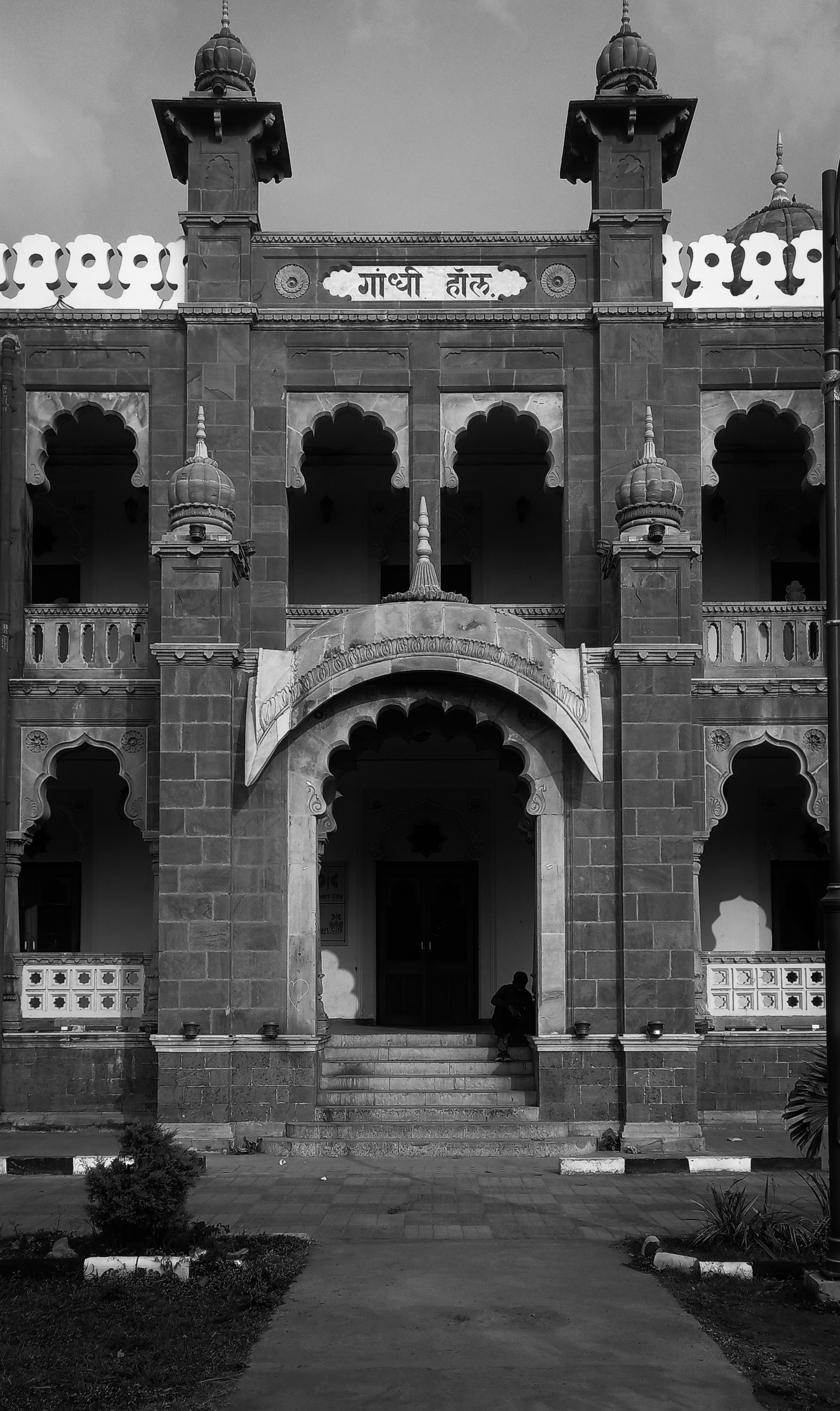 A vintage black and white photo of an ornate building with arches and traditional design elements.