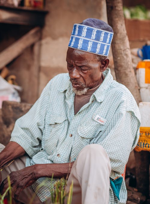 An old man sitting on a bench in a market