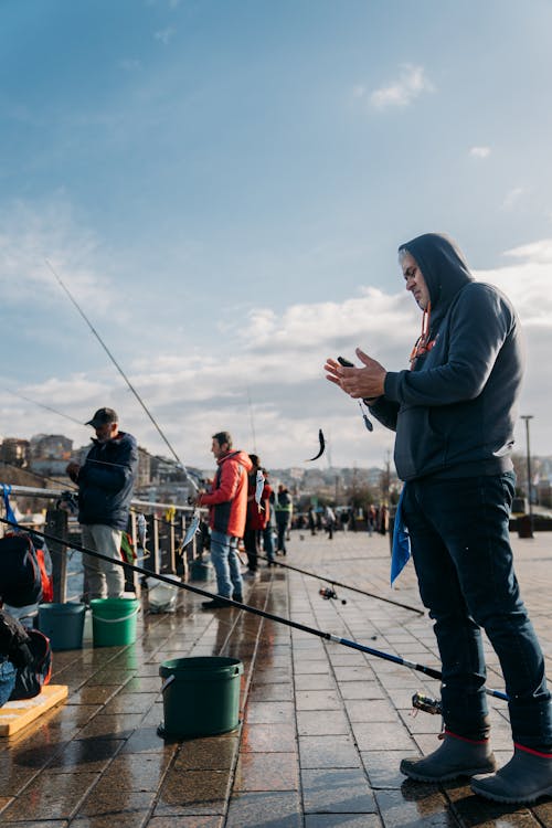 A man standing on the dock with his fishing rod