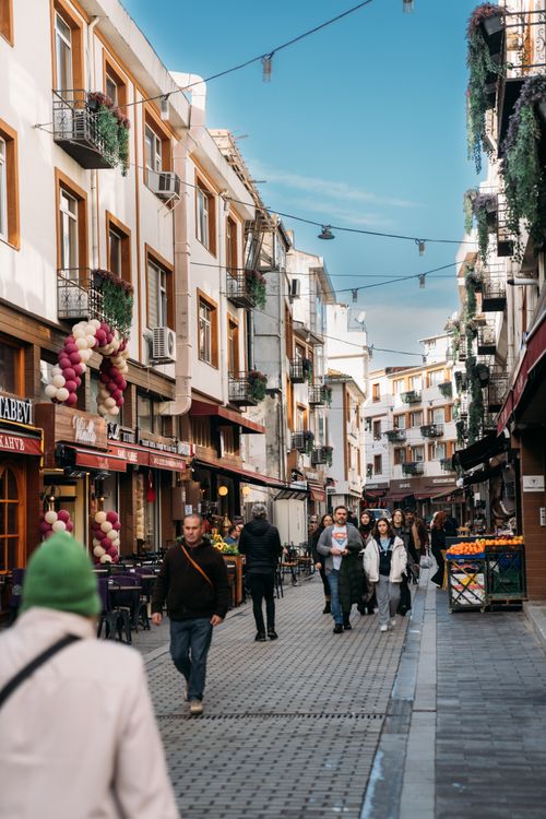 Free City street scene with people walking in a lively market area, surrounded by historic buildings. Stock Photo