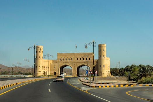 A traditional Omani gateway viewed from the road under clear blue skies.