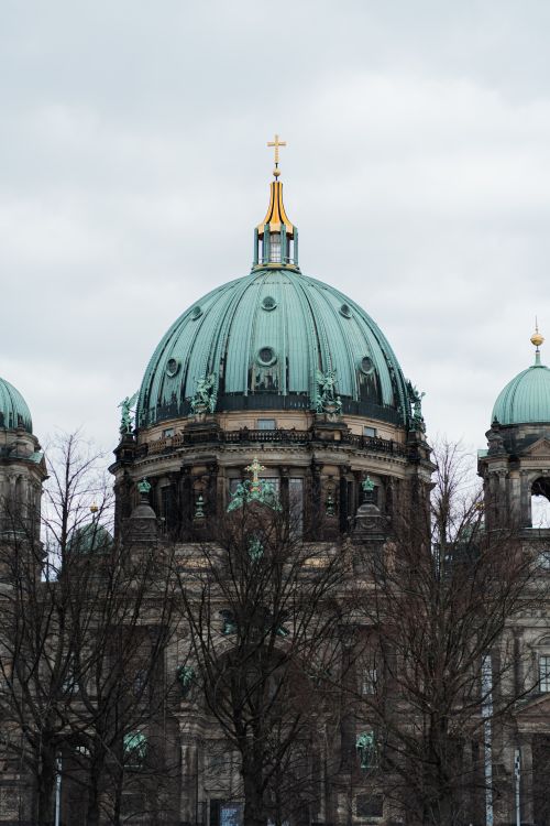 Free A striking view of Berlin Cathedral's dome against a cloudy sky, showcasing its intricate architecture. Stock Photo