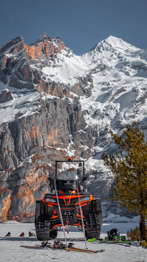 A snowmobile is parked in front of a mountain
