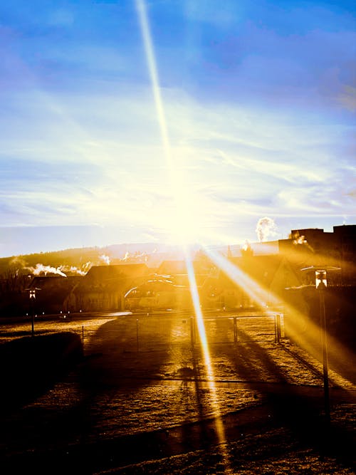 Foto profissional grátis de aldeia, amanhecer cedo, brilho do sol