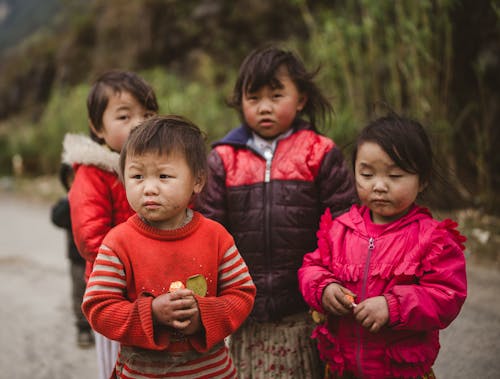 A group of children standing on a road