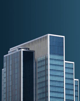 Stunning view of a modern skyscraper with a deep blue sky backdrop, highlighting architectural elegance.