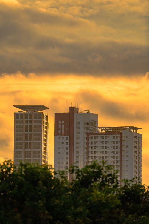 Free Stunning view of Jakarta skyline at dawn featuring modern residential towers under golden clouds. Stock Photo