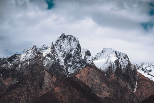 Free Explore breathtaking snow-covered mountain peaks against a cloudy sky in this stunning landscape photograph. Stock Photo