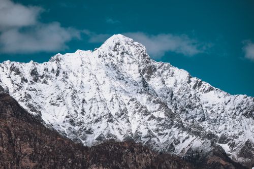Free A striking snow-covered mountain peak set against a vibrant blue sky. Perfect for winter scenes. Stock Photo