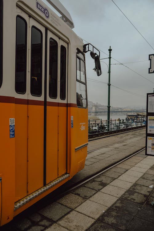 A yellow and orange tram on the tracks