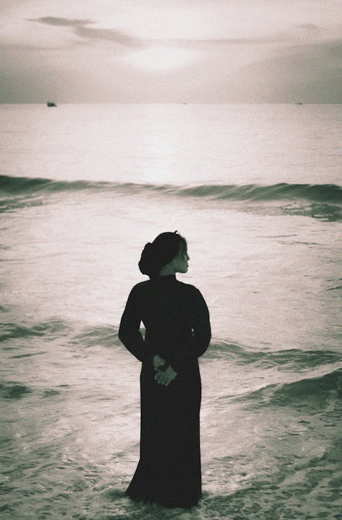 Woman in Black Dress Standing in Ocean